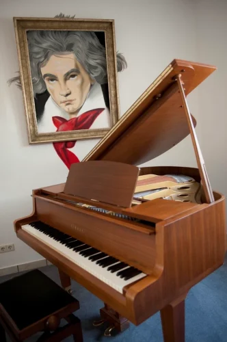 Klavier in einem Schulungsraum im Hintergrund ein Wandbild von Ludwig van Beethoven.