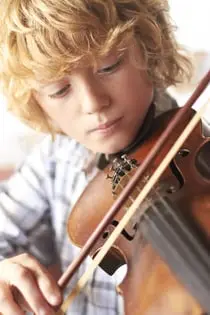 Kleiner Junge spielt konzentriert auf der Geige
